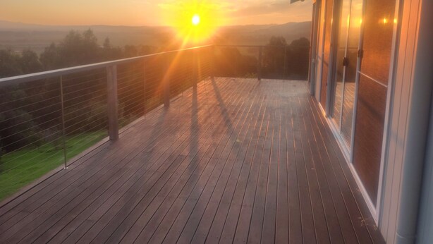 A wooden deck with a glass balustrade overlooking a landscape. - Whole House in Toora on 2 ha. elevated with incredible views to Wilsons Prom (Toora)