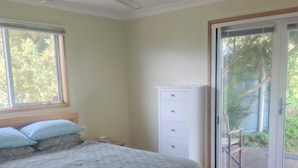 A bedroom with a bed, a ceiling fan, a window, a sliding glass door, and a white dresser. - Whole House in Toora on 2 ha. elevated with incredible views to Wilsons Prom (Toora)