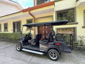Ein Golfmobil steht vor einem Gebäude mit einer Holztür und Fenstern.