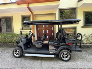 Un cart de golf estacionat davant d'un edifici amb una porta i finestres.