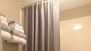 Une salle de bain équipée de toilettes, d’une baignoire et d’un rideau de douche.