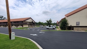 Un hôtel doté d’un parking, un bâtiment avec un toit rouge et une enseigne indiquant le Cranberry Beach Inn Hotel.
