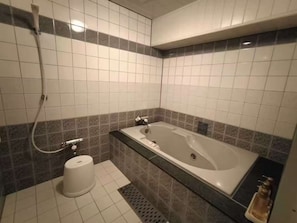 Un baño con bañera, ducha y retrete.