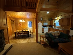 Ein Holzblockhaus-Interieur mit Essbereich, Küche und Wohnzimmer.