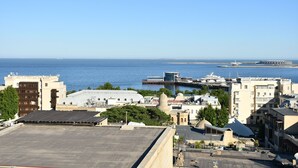 Eine Küstenstadtlandschaft mit Gebäuden, einem Hafen und blauem Himmel.