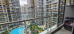 A high-rise residential building with a glass balcony overlooking a swimming pool and children's play area. - Lotus Bloom-Luxe Condo, Amazing View and Location! (Thành phố Hồ Chí Minh)