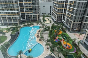 Complejo residencial con piscina, áreas ajardinadas y zona de juegos infantiles.
