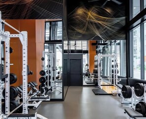 A gym with weightlifting equipment, mirrored walls, and large windows. - High-rise comfort in Midtown; Atlanta’s most walkable neighborhood (Atlanta)