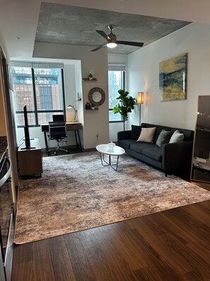 A modern living room with a sofa, coffee table, and a ceiling fan. - High-rise comfort in Midtown; Atlanta’s most walkable neighborhood (Atlanta)