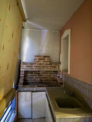 Eine Küche mit Backsteinwand, Spüle und Fenster.