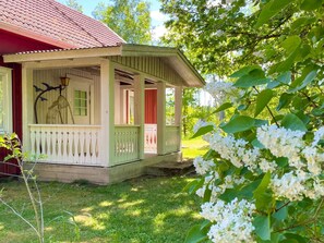 A small, single-story house with a porch, a lamp, and a bird sculpture. - 5 Person Holiday Home in Ruda (Ruda)
