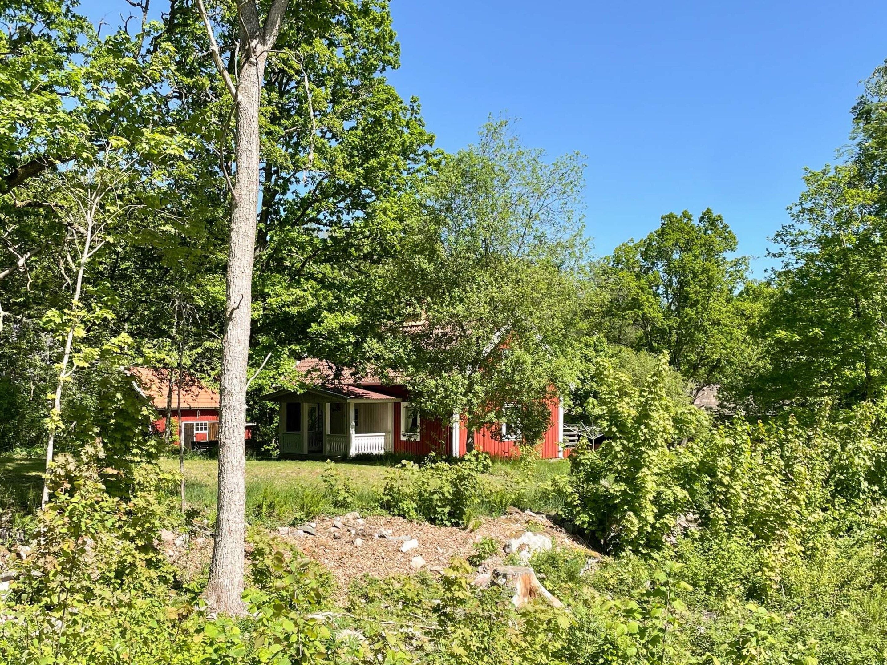 A house surrounded by trees with a clear sky.