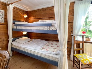 A bunk bed with a canopy, a bedside lamp, and a small table with a yellow tablecloth. - 5 Person Holiday Home in Ruda (Ruda)