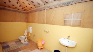 A small, enclosed bathroom with a toilet, sink, and a window. - Mehta Desert Camp (Jaisalmer)