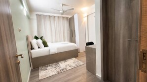 A modern bedroom with a bed, a ceiling fan, a bedside table, and a nightstand.