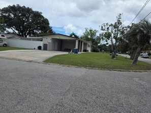 A residential property with a garage, a covered driveway, and a well-maintained lawn.