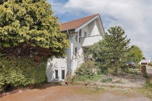 A two-story house with a sloped roof, a front door, and a visible garage.