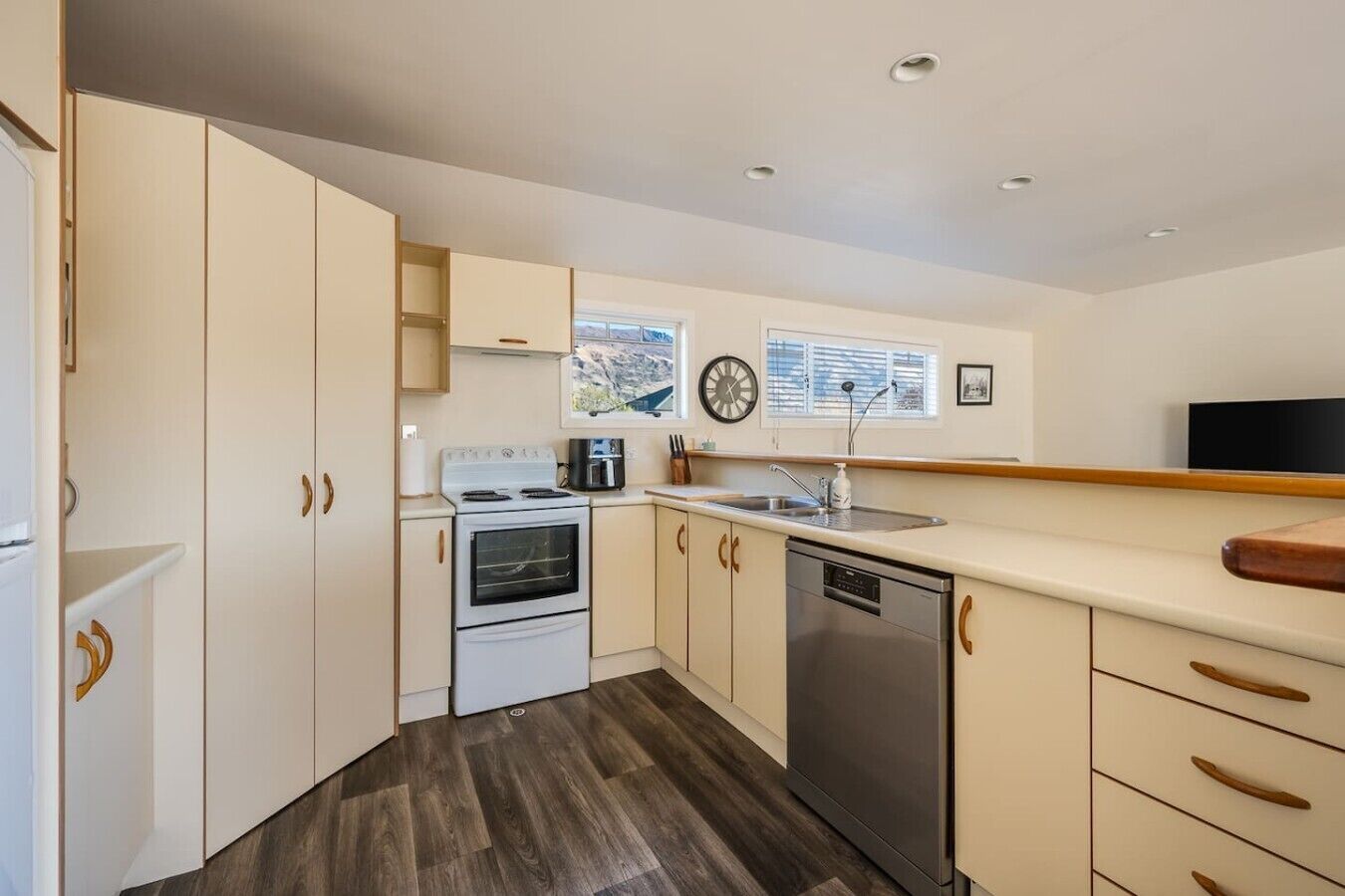 A compact kitchen with a stove, oven, dishwasher, and a sink.