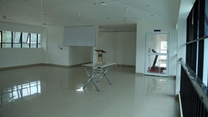 A spacious, modern room with a large window, ceiling fans, and a podium.