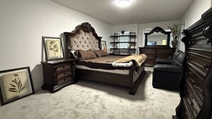 A bedroom with a large bed, a dresser, a nightstand, a mirror, and a plant. - Room-elegant Private Room With En-suite (Edmonton)