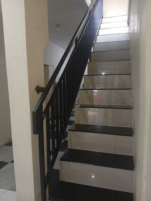 Eine Treppe mit schwarzen Geländern und beigen Stufen.