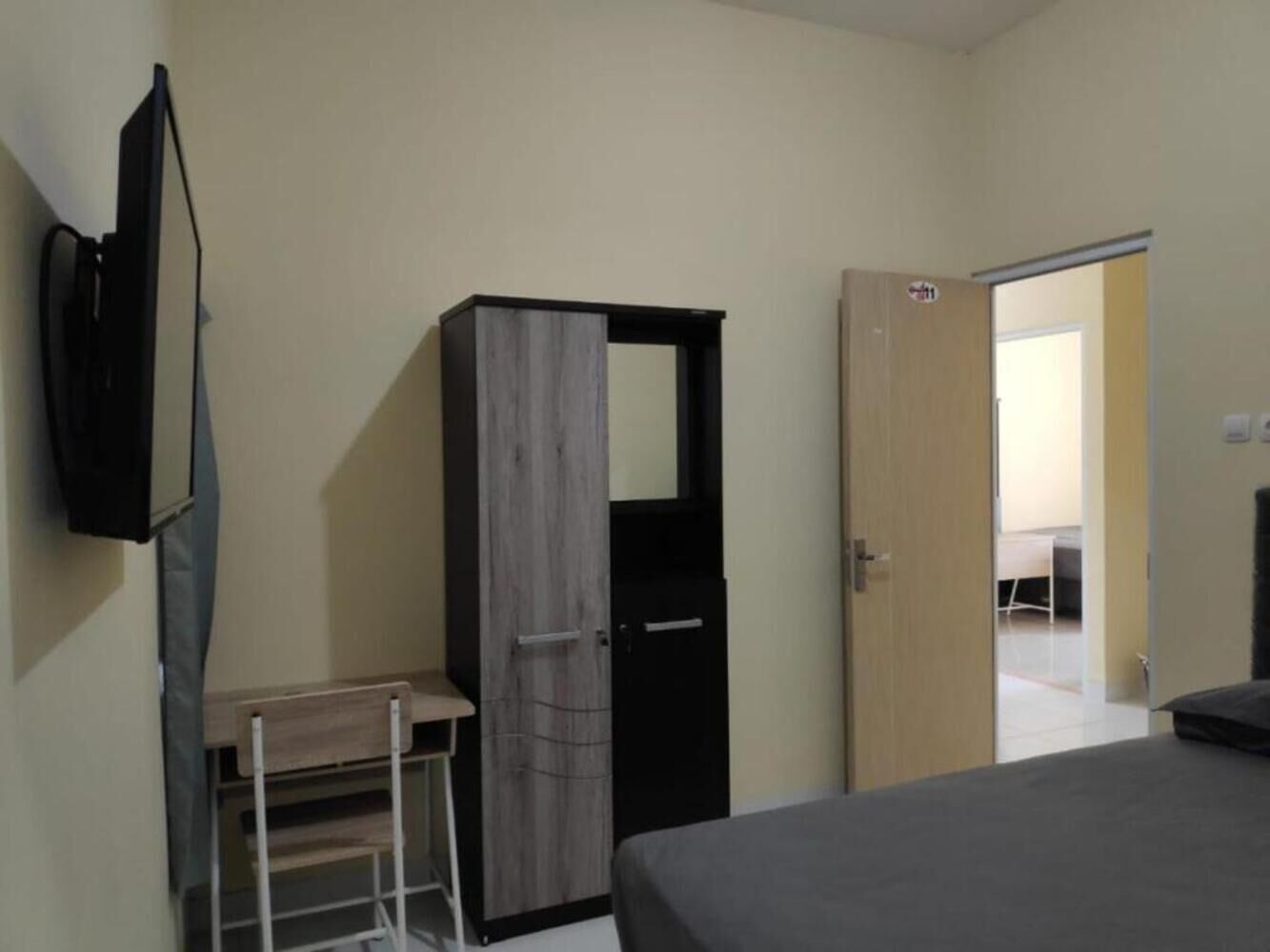 Une chambre à coucher comprenant un lit, une armoire, un bureau et un téléviseur.