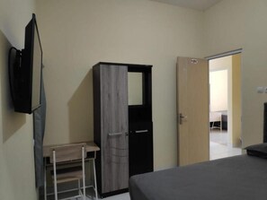 Une chambre à coucher comprenant un lit, une armoire, un bureau et un téléviseur.