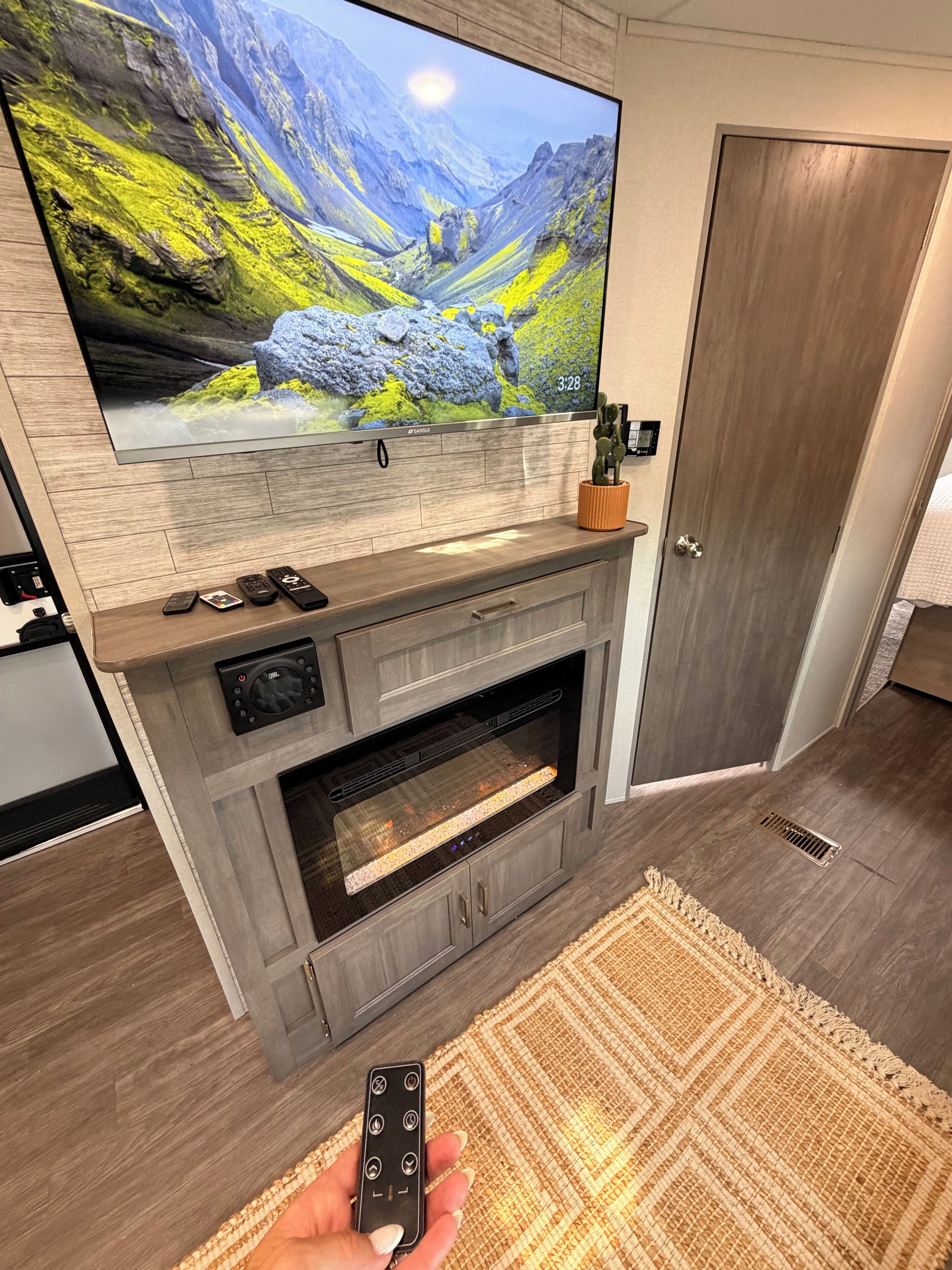 Una sala de estar moderna con un televisor de pantalla plana grande, una chimenea y un control remoto.