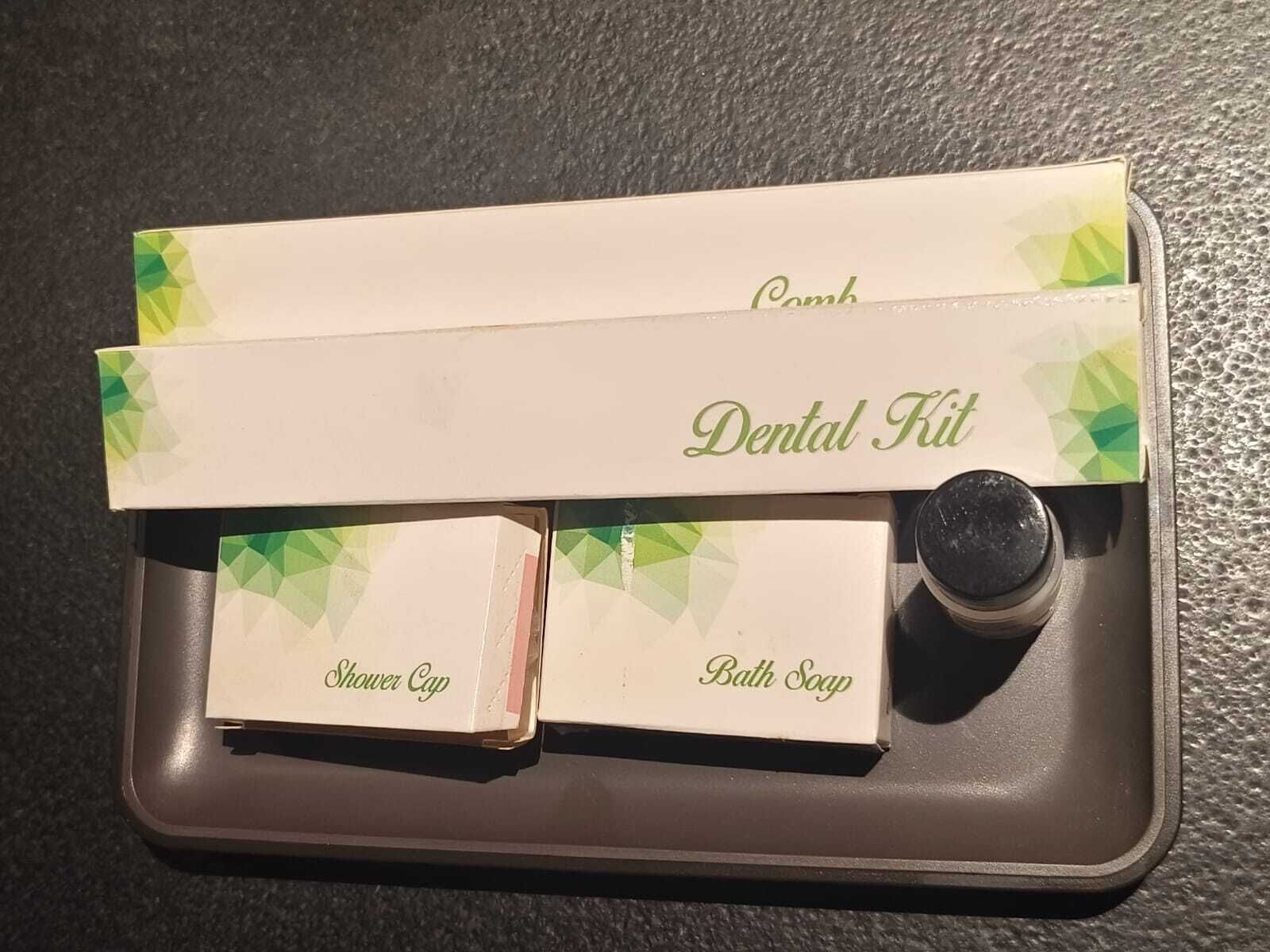 Une trousse de toilette contenant une brosse à dents, un bonnet de douche et un savon.