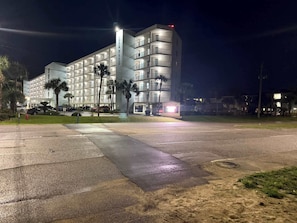Un hôtel à plusieurs étages doté d’une cour intérieure, de palmiers et d’une enseigne indiquant « Sea Crest ».