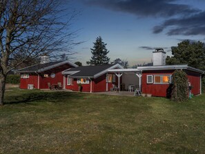 A red two-story house with a covered patio and a chimney. - 5 Star Holiday Home in Vejby (Vejby)