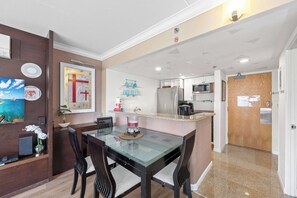 A modern kitchen with a microwave, refrigerator, and a wooden door. - @ Marbella Lane - Iconic Waikiki City View Getaway (Honolulu)