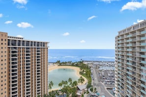 Ein hoch aufragendes Hotel mit Blick auf einen Strand, einen Parkplatz und den Ozean.