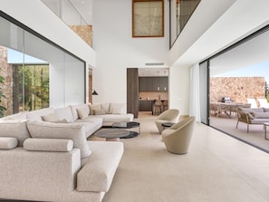 A modern interior with a sectional sofa, round coffee table, and dining area with chairs. - Villa The Address by Vacation Marbella (Marbella)