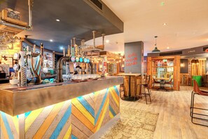 A bar area with a wooden counter, multiple taps, and a sign reading 'JERKS MALICAN CRAZY'. - Relax in a Contemporary Space Perfect for City Adventures – Prime Location (Manchester)