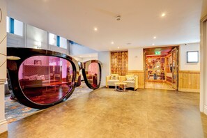 A spacious lobby with a large mirror, a seating area, and a view into the restaurant. - Relax in a Contemporary Space Perfect for City Adventures – Prime Location (Manchester)