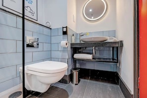Et moderne badeværelse med toilet, vask og spejl.