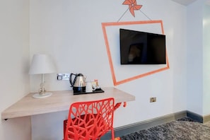 A small room with a desk, a chair, a TV mounted on the wall, and a lamp. - Stay Central with Easy Access to Transport & Local Adventures (Manchester)