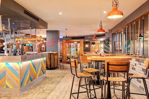 Eine Bar mit Barhocker, Theke und einem Schild mit der Aufschrift 'SMILE'.
