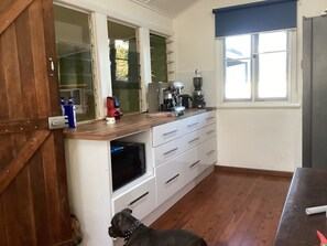 A kitchen with a wooden countertop, a microwave, and a coffee maker.