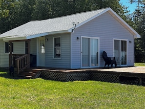 A single-story house with a covered porch, a sliding glass door, and a small deck.