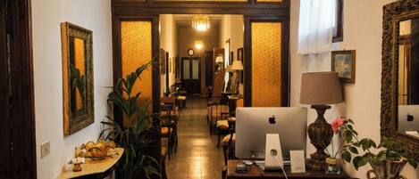 A hotel corridor with a central open space, wooden paneling, and a chandelier.