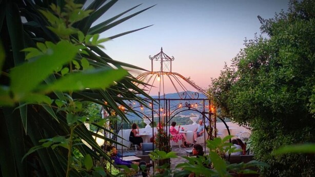 An outdoor seating area with tables and chairs, surrounded by greenery. - Boutique Hotel Golfo Azzurro (Capoliveri)