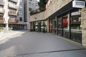 Un edificio moderno con vetrina in vetro, una bicicletta parcheggiata fuori e un cartello che indica un ristorante chiamato 'XIKE MALATANG'.