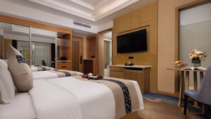 Een hotelkamer met een bed, bureau, stoel, televisie en spiegel.