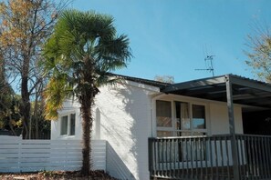 A white building with a balcony, a palm tree, and a clear sky. - Cosy Family Retreat | Minutes to Hospital & Woden (Garran)