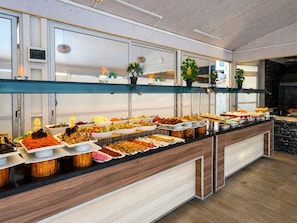 A buffet with various food items, a wooden counter, and a modern kitchen area. - SAYGILI BEACH HOTEL (Manavgat)