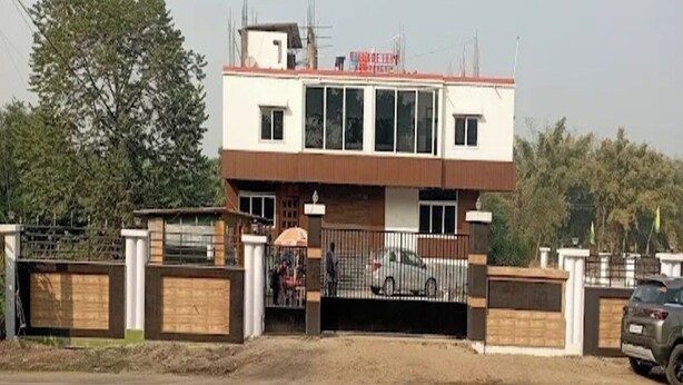 A two-story building with a gated entrance, a small structure on the roof, and a sign above the main entrance. - Village Inn Residency (Kharagpur)