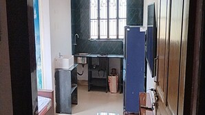 A room with a glass table, a sink, a window, and a wardrobe. - Village Inn Residency (Kharagpur)