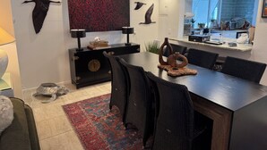 A modern dining area with a dark wood table, black chairs, and a red patterned rug. - The Pink Beach House in Delray Beach for a perfect getaway (Delray Beach)
